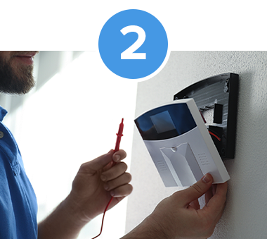 security technician holding tester for home automation system checking